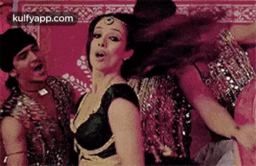 a woman is dancing in front of a group of dancers in a room .