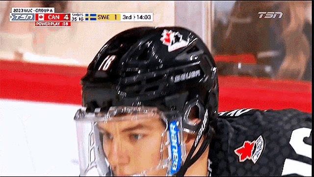 a hockey player wearing a bauer helmet looks down at something