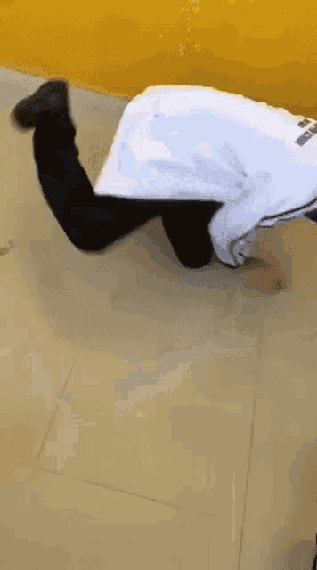 a man in a white coat is kneeling on the floor .