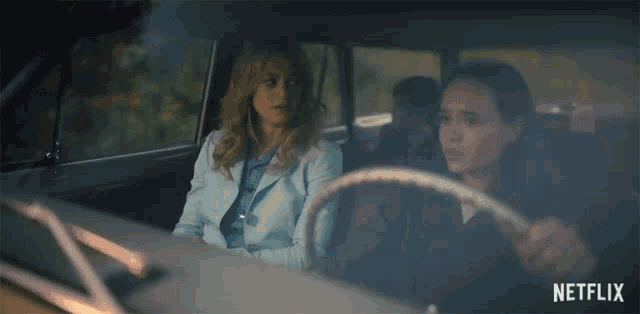two women are sitting in a car with netflix written on the bottom