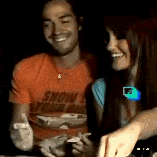 a man wearing an orange shirt that says show your bike smiles next to a woman