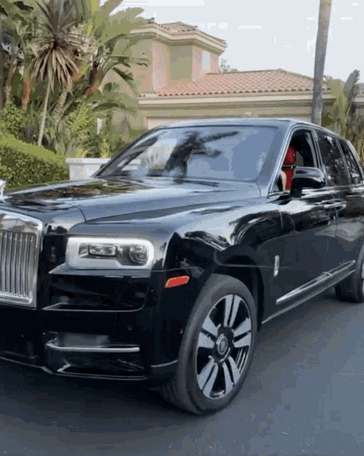 a black rolls royce is parked on the side of the road