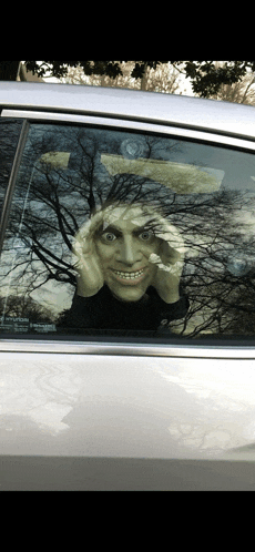 a car with a mask on the windshield that looks like a ghost