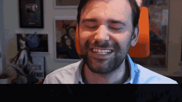 a man with a beard is smiling while wearing headphones