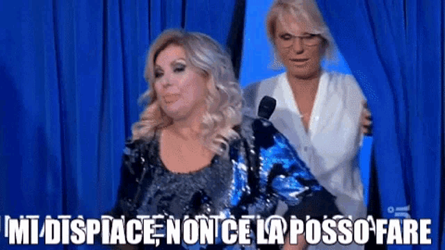 two women are standing in front of a blue curtain with the words " mi dispiace non ce la posso fare " on the bottom