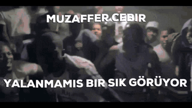 a blurry picture of a crowd of people with the words muzaffer cebir written on the bottom