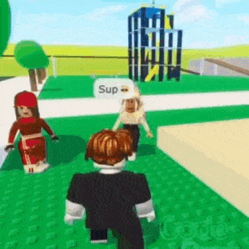 a boy and a girl are playing a video game in a park and the boy is talking to the girl .