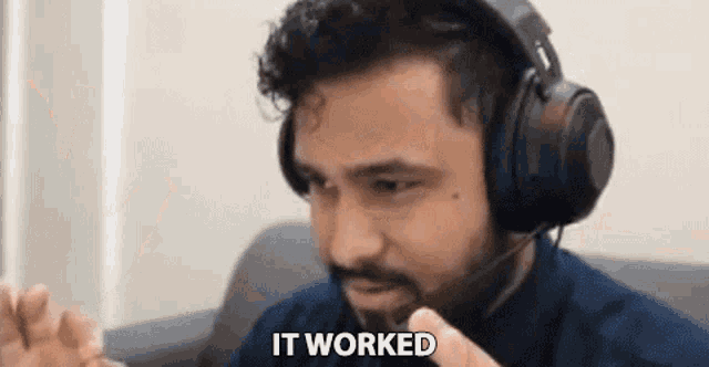 a man wearing headphones and a headset is sitting on a couch and says `` it worked '' .