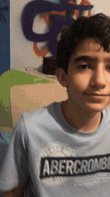 a young boy wearing a blue abercrombie shirt