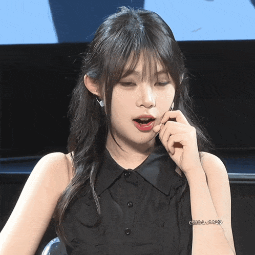 a woman wearing a black shirt and a bracelet that says ' good ' on it
