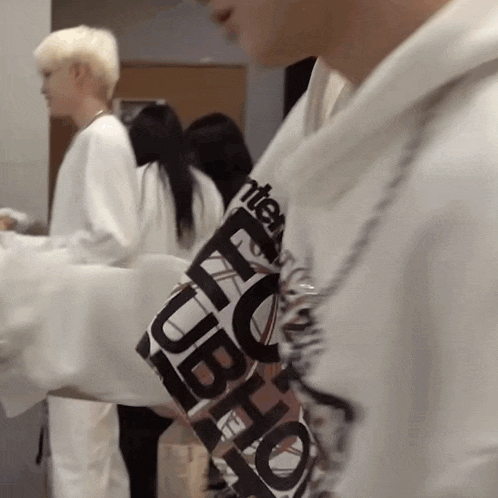 a close up of a person wearing a white hoodie with a black and white logo on it