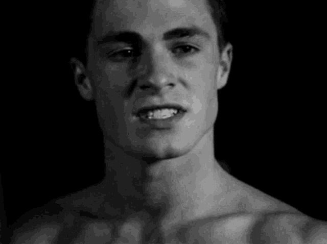 a black and white photo of a shirtless man 's face .