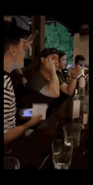 a group of people are sitting at a table with glasses and bottles of alcohol