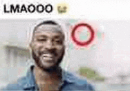 a man with a beard is smiling in a blurry photo with a red circle in the background .