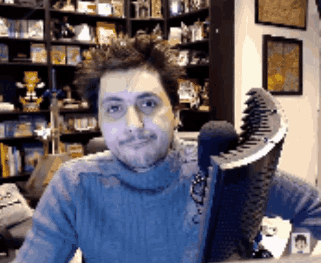 a man in a turtleneck sweater is sitting in front of a keyboard