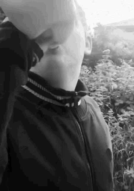 a black and white photo of a man with his hand on his face