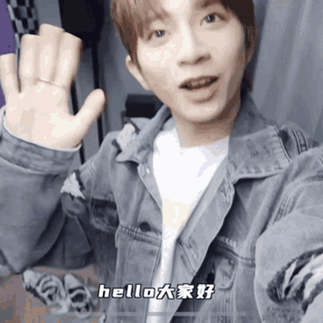 a man in a denim jacket says hello in a foreign language