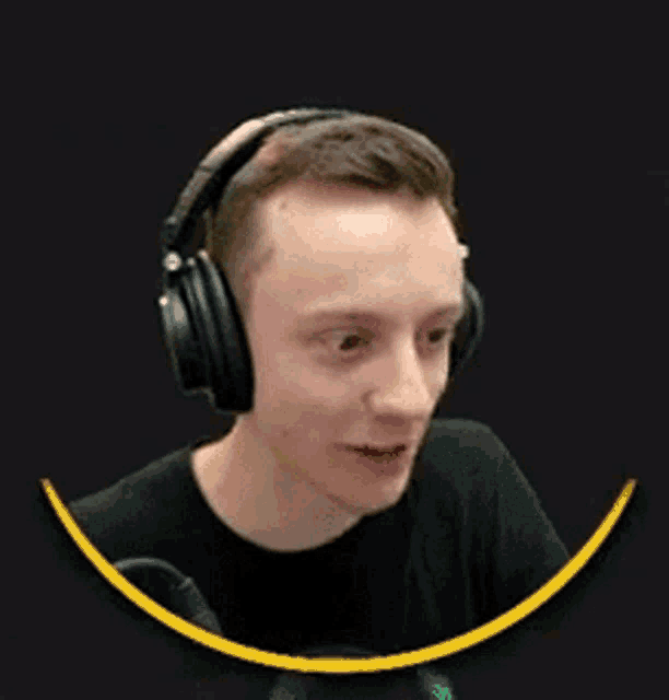 a man wearing headphones is sitting in front of a microphone on a black background .