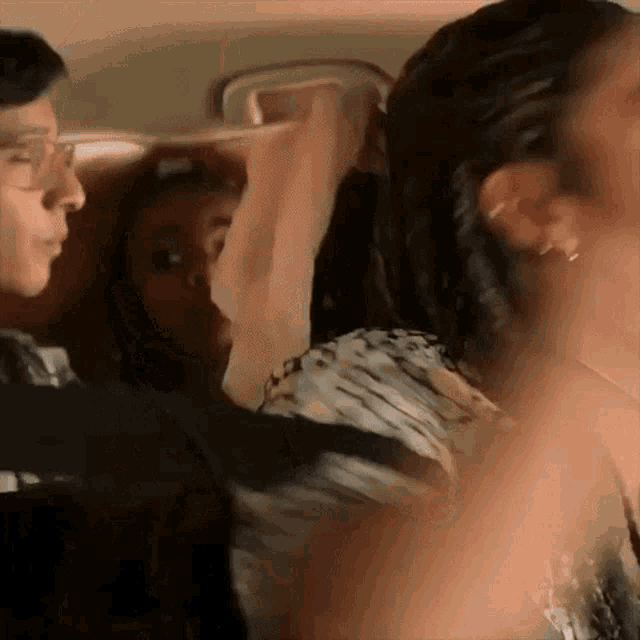 a man and a woman are sitting in a car talking to each other