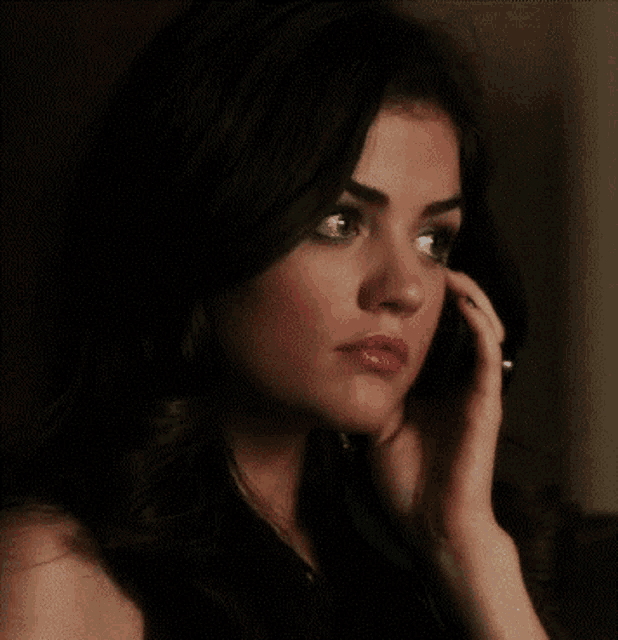 a woman talking on a cell phone with her hand on her ear