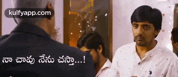 a man in a white shirt is talking to another man in a room in telugu .