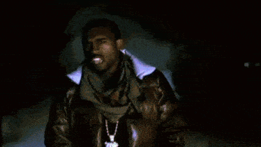 a man in a leather jacket and scarf is standing in front of a blue background