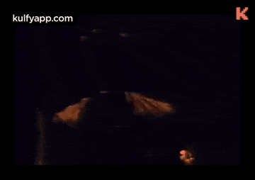 a man with a beard is smiling and giving the ok sign in a dark room