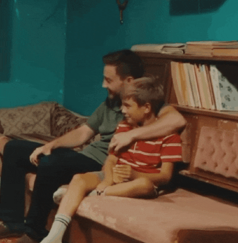 a man and a boy are sitting on a couch together