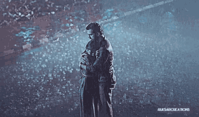 a picture of a man and woman hugging in the rain with ruksarcreations written on the bottom