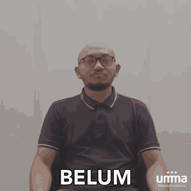 a man wearing glasses and a black shirt with the word belum written on it