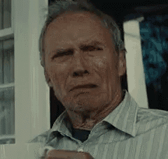 a man in a striped shirt is looking at the camera while holding a cup of coffee .