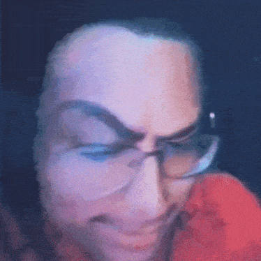 a close up of a man 's face with glasses on .