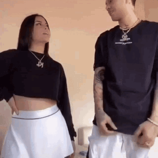 a man and a woman are standing next to each other .