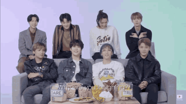a group of young men are sitting on a couch with a box that says dare
