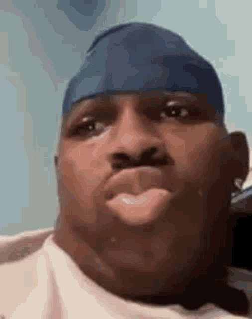 a close up of a man wearing a blue headband making a face .