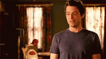 a man in a blue shirt is standing in a living room .