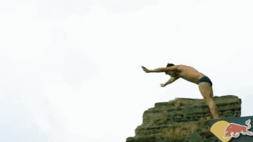 a man is jumping off a diving board with a red bull logo on it