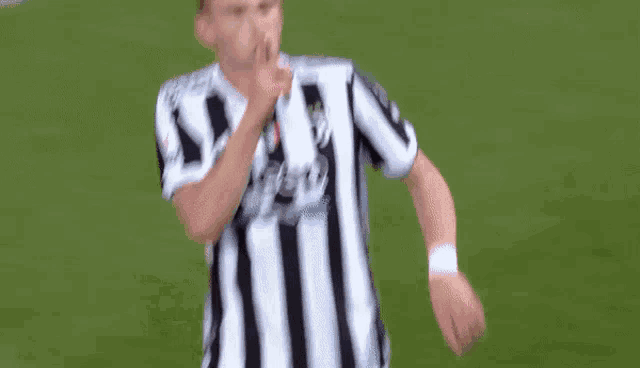 a soccer player wearing a black and white striped shirt with the word jeep on it .