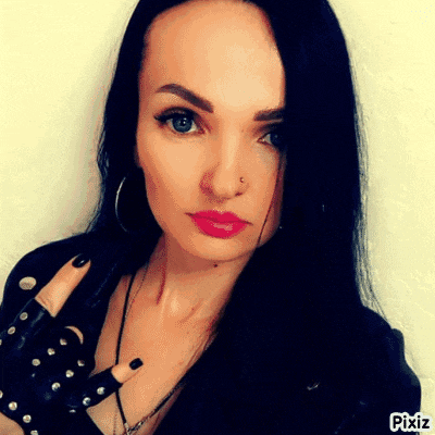 a woman with long black hair is wearing a black leather jacket and black gloves