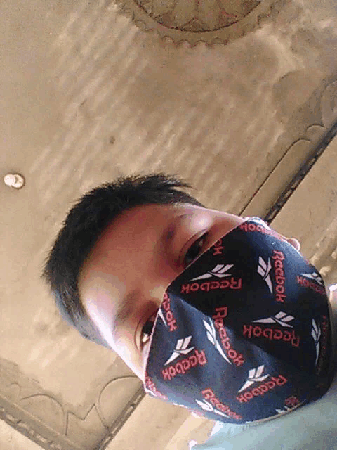 a man is wearing a reebok face mask