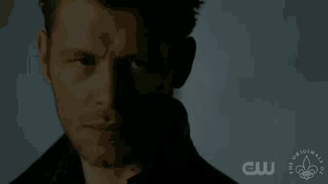 a close up of a man 's face with a cw logo on the bottom