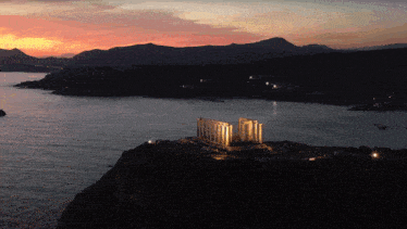 a large building sits on top of a cliff overlooking the ocean