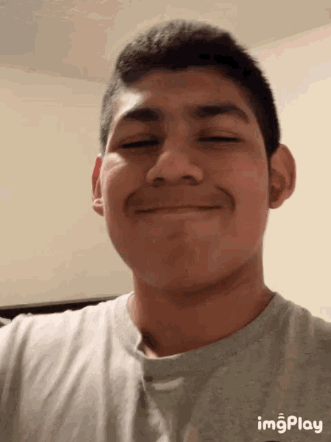 a young man 's face is shown in a gif with the words imgplay below it