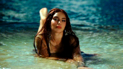 a woman is laying in the water with her feet up .