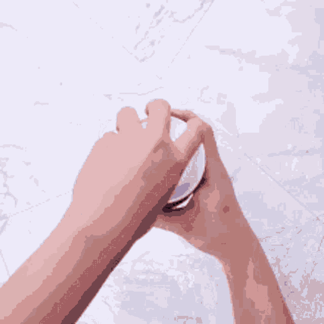 a close up of a person 's hand holding a white object