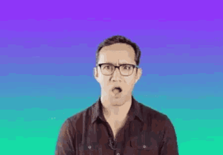 a man wearing glasses and a brown shirt is making a fist gesture .
