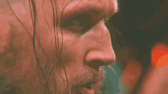 a close up of a man 's face with a red eye