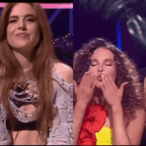 two women are standing next to each other with one blowing a kiss
