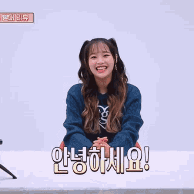 a girl in a blue sweater with a heart on it is smiling