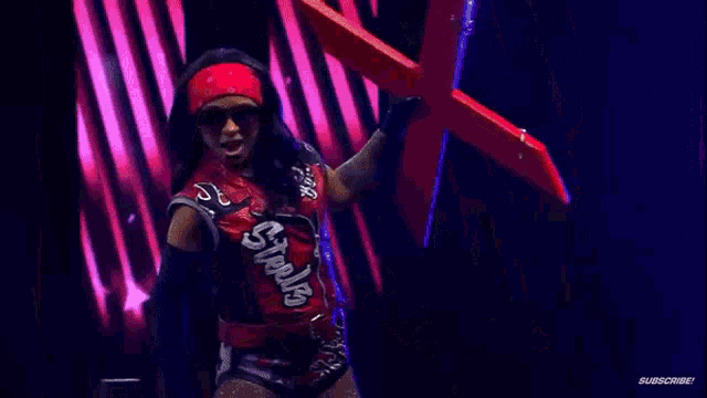 a woman in a red vest with the word steelz on it is holding a red object in her hand .